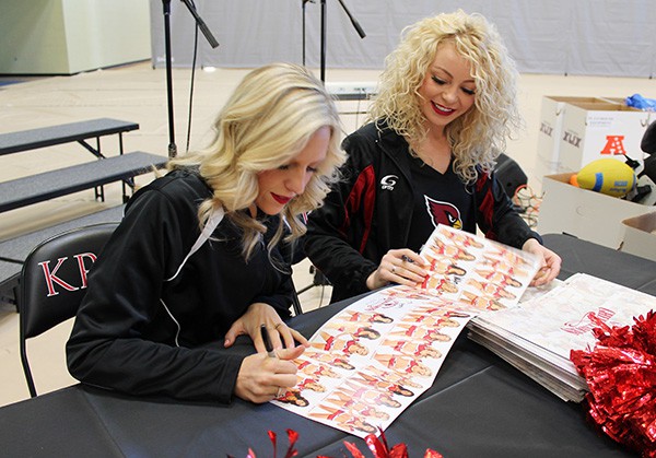 Arizona Cardinals cheerleaders Brooke (left) and Erica (right) sign autographs for students before the Kids Camp. Photo by Miranda Perez