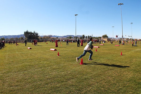 Participants run, jump, pass and catch in a rotation of drills on a sunny day outside of the Salvation Army South Mountain Kroc Community Center. Photo by Miranda Perez