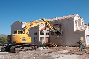 A crew starts demolishing an Ahwatukee home Thursday, Aug. 27, to make way for the planned South Mountain Freeway.