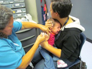 Kristin Fields holds her daughter Leah, 18 months, as Maricopa County Department of Public Health nurse Pearl Napa administers seven vaccine shots at a clinic in Glendale on Nov. 28, 2012. Fields said she considers vaccines vital to protecting her daughter's health.