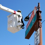 Crews outside US Airways Center install a “3 Championship Way” street sign atop First Street at East Jefferson Street on Friday, Sept. 11, 2015. The Mercury enter the playoffs as the No. 2 seed, looking for their fourth title. (Cronkite News photo by Evan Webeck)