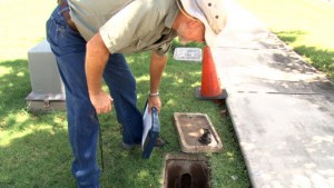 Jeff Lee, a water conservation specialist for the Town of Gilbert, examines a water meter during an audit of a home’s water use. (Photo by Audrey Weil/Cronkite News)