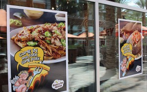 Signs adorn the exterior windows of French Fry Heaven’s Tempe location. (Photo by Jason Axelrod/Cronkite News)