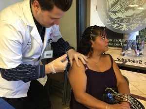 Paul Stoneburg, a pharmacist, gives a free flu shot offered by the Mexican Consulate in Phoenix. (Photo by Bailey Netsch/Cronkite News)