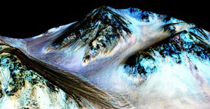 Dark streaks on the slopes of Hale crater of Mars are believed to be evidence that water flows on the planet. This image exaggerates the vertical. (Photo by NASA/JPL/University of Arizona)