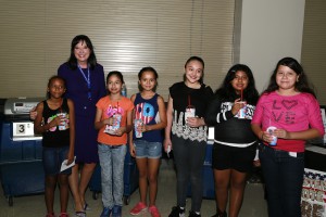 With voting machines behind them, Secretary of State Michele Reagan and students from Larry C. Kennedy School in Phoenix mark School Day at a recent Phoenix Mercury game.