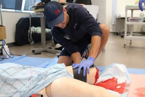 Phoenix firefighter Nathan Philips practices applying a tourniquet on one of the high-tech mannequins at the Center for Simulation and Innovation at the University of Arizona College of Medicine-Phoenix.