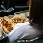 A fan enjoys a hot dog that is covered with pulled pork and mac and cheese at a Diamondbacks game. (Cronkite News photo by Kevin Jimenez)