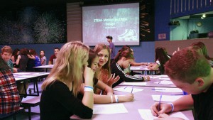 Anthem School eighth graders study at tables set up on the roller rink at Great Skate in Glendale during a STEM field trip. The students studies the friction involved in rollerskating. (Photo by April Morganroth/Cronkite News)