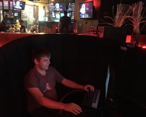 Dillon Thompson plays League of Legends on a desktop computer in a booth at Endgame Bar. (Photo by Jason Axelrod/Cronkite News)