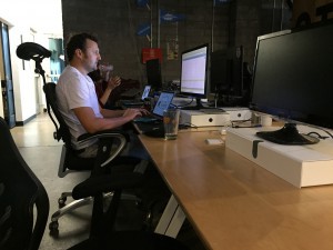 Pierre Kaluzny, founder of Sputnik Moment, works at his workstation at Co+Hoots in Phoenix. (Photo by Jason Axelrod/Cronkite News)