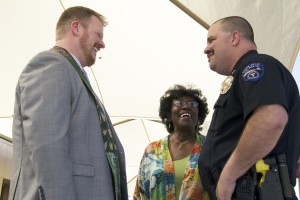 Valley Unitarian Universalist Church Rev. Andy Burnette (left) chats with Tempe police officer Noah Johnson, who supports the church’s cause, and Beverly McCormick, who supervises the program. (Photo by Becca Smouse/Cronkite News)