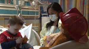 Eydie Fernandez, a child life specialist, watches Nolan Nikolic-Dzaka, an asthma patient at the Phoenix Children's Hospital, play with a Mr. Potato Head toy. (Photo by Yahaira Jacquez/Cronkite News)