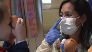 Eydie Fernandez, a child life specialist, plays with Nolan Nikolic-Dzaka, an asthma patient at the Phoenix Children's Hospital. (Photo by Yahaira Jacquez/Cronkite News)