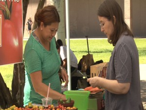 A shopper makes a purchase at one of the stands at the Capitol Farmer’s Market.