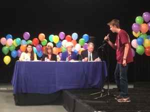 One contestant grips the mic as he spells a word, and the judges check for accuracy. (Photo by Gilbert Cordova/Cronkite News)