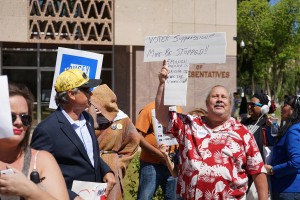 Richard Sitongia of Phoenix, holds up a sign during a protest at the state Capitol on Wednesday. Sitongia, a Bernie Sanders supporter, was protesting the Maricopa County Recorder's Office and the way it handled the presidential preference election on Tuesday. A concurrent protest at the Capitol on the same day focused on immigration issues. (Photo by Travis Arbon/Cronkite News)