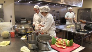 Three chefs prepare salads during their training at the Arizona Culinary Institute in Scottsdale, Arizona. (Blake Benard/Cronkite News)