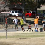 A group of disc golfers watch as a shot carries towards a basket at Vista del Camino Park in Scottsdale. (Photo by Rian Bosse/Cronkite News)