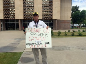 Phoenix resident Lennie Clark, 51, protests the new reporter background check outside the state House in Phoenix on April 7, 2016. (Photo by Miguel Otárola/Cronkite News)