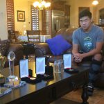 Josh Xu stares at the trophies he’s already won in his short tennis career. But with the boot on his injured foot, he also thinks about the trophies he’ll miss out on. (Photo by Michael Boylan/Cronkite News)