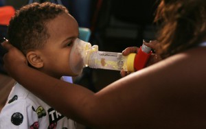 Lassandra Scott helps her four-year-old son, Zaviyon, use his inhaler just seconds after he was wheezing. (Photo by Alejandra Armstrong/Cronkite News).