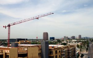 A crane hovers over one of the many apartment complexes sprouting up along Roosevelt Street in downtown Phoenix. The crew is working on the Linear apartment complex to be completed by the end of 2016. (Photo by Lindsay Robinson/Cronkite News)
