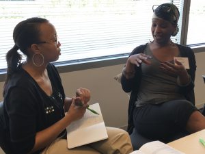 Two attendees speaks to one another at the Women of Color STEM Entreprenurship Conference to encourage women of color to own businesses. (Photo by Elizabeth Hansen/Cronkite News)