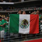 Supporters of the Mexican National Soccer Team pose with the Mexican flag just before the start of the game. (Photo by: Joe Steen/Cronkite News)