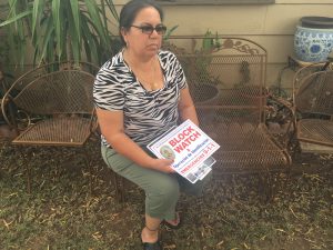 Flora Bhehea, a 22-year resident of Maryvale, holding the flyers and block watch poster given to her by the patrol. (Photo by Selena Makrides/Cronkite News)
