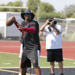 Phoenix College receivers coach Kerry Taylor throws passes to high school receivers at Camp 29, a summer high school football camp in Gilbert. (Photo by John Alvrado/Cronkite News)