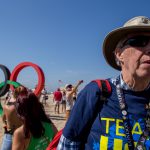 Chuck Brandt looks over at his family in front of the Olympic rings on Copacabana Beach in Rio de Janeiro. (Photo by Courtney Pedroza/Cronkite News)