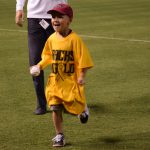 Six-year-old Bruce Clark-Frye runs back after getting his baseball autographed on the field during player introductions at the D-backs Go Gold for Cancer Awareness Game. (Photo by Giselle Cancio/Cronkite News)