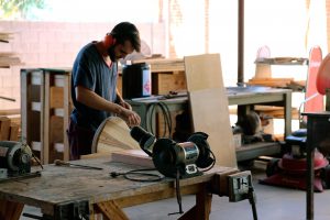 Daniel Eory, a 22-year-old student at the Roberto-Venn School of Luthiery, sands down a guitar. (Joshua Bowling/Cronkite News)