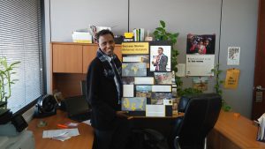 Mohamed Abdullahi, a former Somalian refugee who resettled in Arizona, now helps other refugees to life in the U.S. Abdullahi will vote for the first time in November. He celebrates his success with a poster board. (Photo by Jesse Canales/Cronkite News)