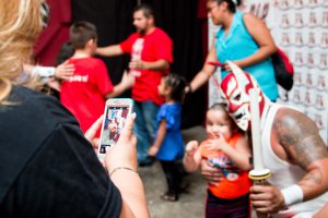 A young fan gets a photo with the luchadore El Diablo after a P.o.r. Promotions show in Glendale. (Photo by Kelsey DeGideo/Cronkite News)