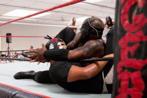 Beast ties up with Rompecabezas in the corner of the ring at a P.o.r. Promotions event in Phoenix. (Photo by Christopher West/Cronkite News)