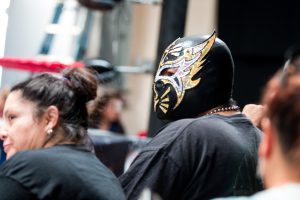 A masked spectator watches the lucha libre action in Glendale. (Photo by Christopher West/Cronkite News)