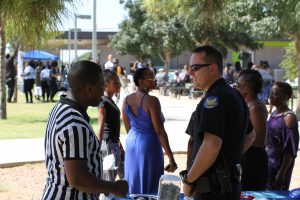 Jarvis Johnson talks with Phoenix police Officer Chad Sullivan at a National Day of Nonviolence event in Hermoso Park in Phoenix. Sullivan is a community action officer who builds relationships with residents in the South Mountain Precinct. (Photo by Cassie Ronda/Cronkite News)