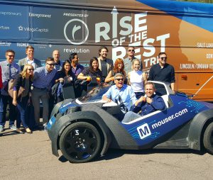 The Rise of the Rest team and Local Motors pose in front of the tour bus with 3-D printed longboards and a 3-D printed car. (Photo by Gavin Maxwell/Cronkite News)