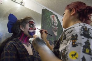 Makeup artists like Serina Felix apply makeup to clowns, ghouls and zombies at Fear Farm, a haunted attraction in the West Valley. (Photo by Ally Carr/Cronkite News)