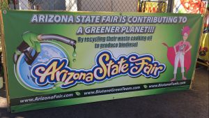 Vendors pour used cooking oil into receptacles tucked behind signs at the Arizona State Fair.(Photo by Natalie Tarangioli/Cronkite News)