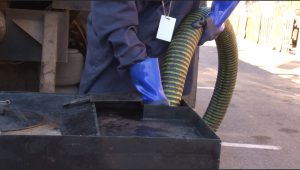 A Biotane Pumping worker removes cooking oil from one of the receptacles placed around the Arizona State Fair. The company recycles used oil into biodiesel. (Photo by Natalie Tarangioli/Cronkite News)