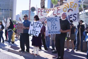 Protesters resisting the Dakota Access Pipeline stand with their signs outside of the U.S. Army Corps of Engineers in downtown Phoenix. (Photo by Bri Cossavella/Cronkite News)