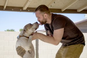 John Koch, 28, plays with his dog Conrad outside his Mesa home. Koch is a recovering opiate addict who has been pronounced legally dead three times. He has been sober for nearly a year. (Photo by Ben Moffat/Cronkite News)