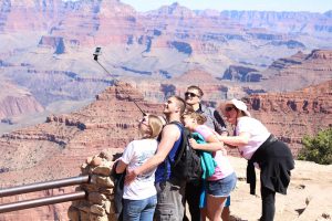 Tourists pose for a selfie in Grand Canyon National Park. (Photo by Sophia Kunthara/Cronkite News)