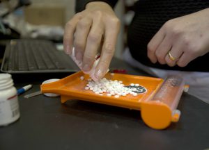 A pharmacist works with pills at Melrose Pharmacy in Phoenix. (Photo by Johanna Huckeba/Cronkite News)