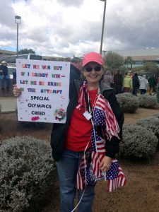 Former special education teacher Elizabeth Holmes, 54, holds a poster to showcase Special Oolympic students. (Photo by Saundra Wilson/Cronkite News)