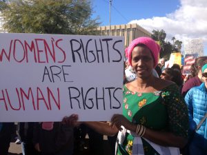 Human rights activist Rose Mapendo sports a pink hat”and dress from her native Congo at a Phoenix march in solidarity of the Women’s March on Washinton. (Photo by Saundra Wilson/Cronkite News)