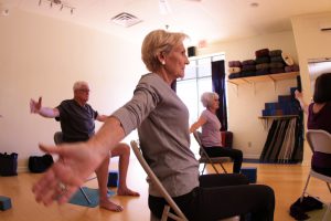 Lin Morse (front), Larry Litchfield and Gloria Tucker take a chair yoga class at Inner Vision Yoga Studio in Chandler. (Photo by Ao Gao/Cronkite News)